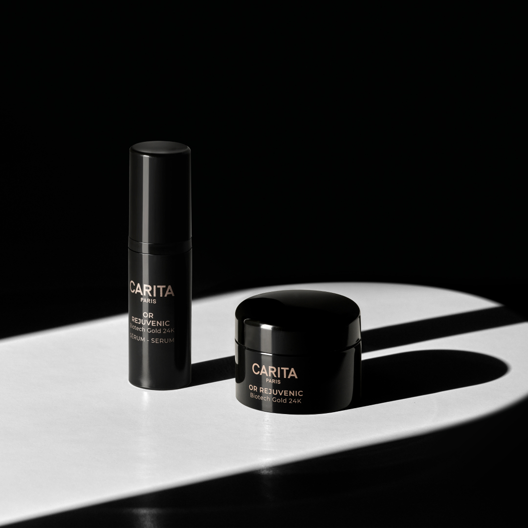 Two sleek black skincare products, a serum and cream, sit on a white surface with dramatic lighting, showcasing a luxurious aesthetic.